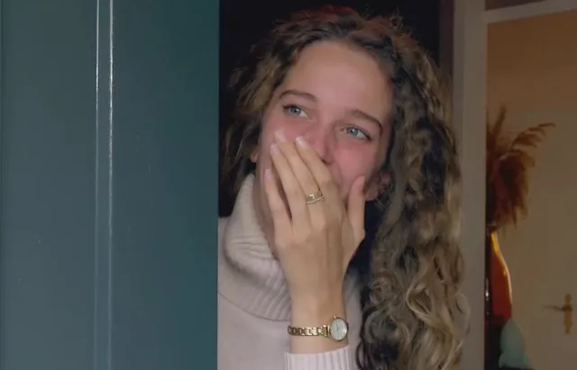 Edi Hoefnagel slaat verrast een hand voor haar mond als ze wordt verrast voor het EO-programma het familiediner.