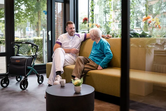 Zorgprofessional van het jaar finalist Roel in op zijn werk in gesprek met een oudere.