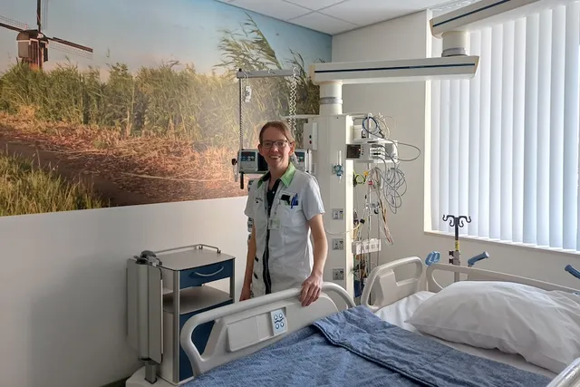Zorgprofessional van het jaar finalist Alida in haar werkkleding naast een ziekenhuisbed.