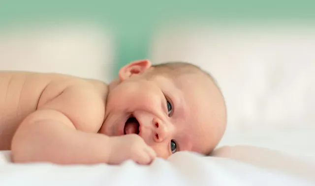 Innemend lachende baby.