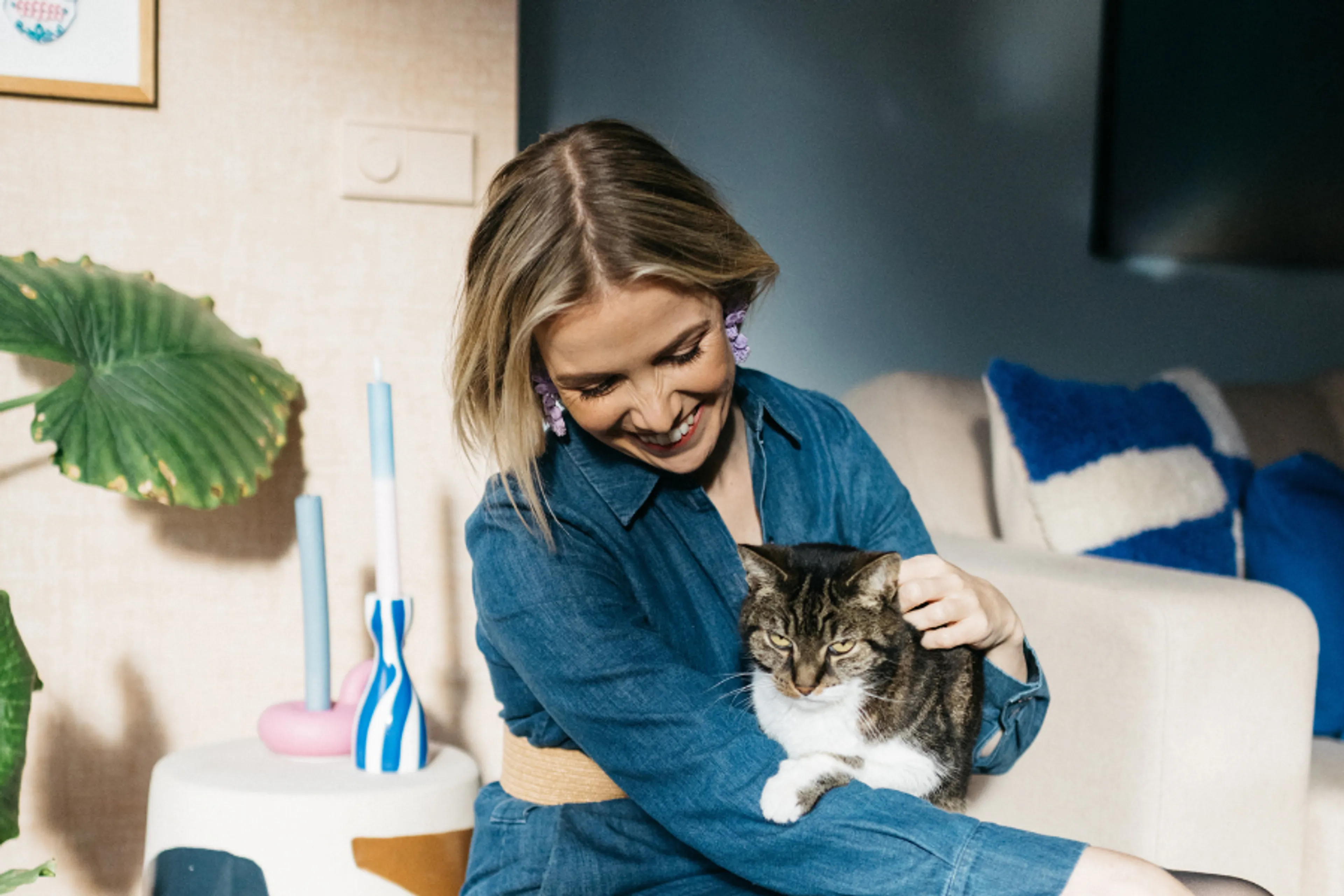 Afbeelding van Marije Duijn, met haar kat Fonsi op schoot en haar interieur zichtbaar op de achtergrond