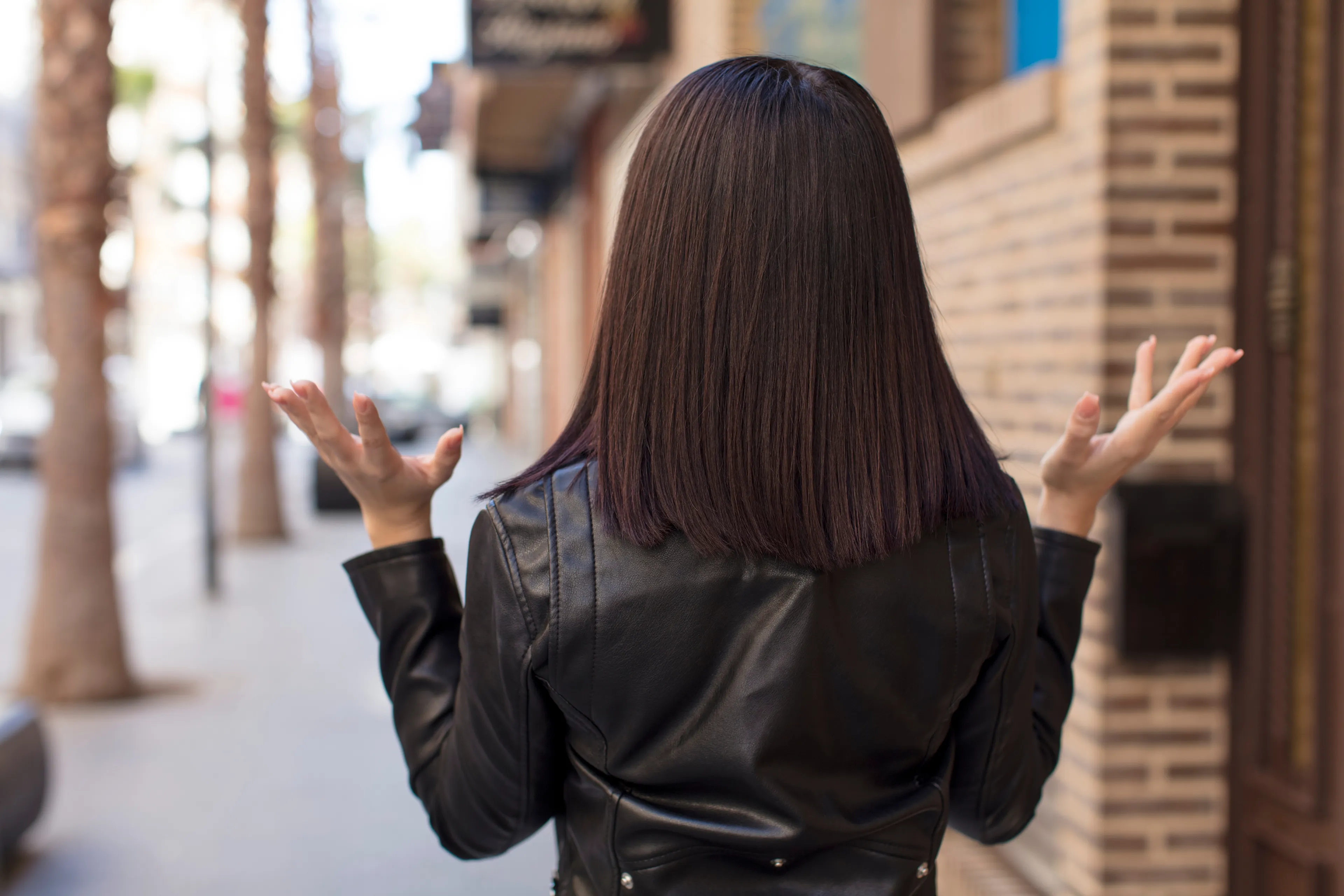 vrouw van achterkant met armen gefrustreerd omhoog
