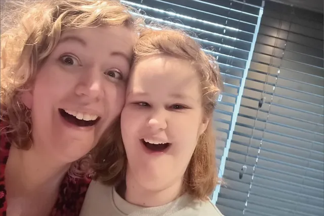 Germa en haar dochter lachen samen in de camera. Ze hebben beide blond haar en een brede lach.