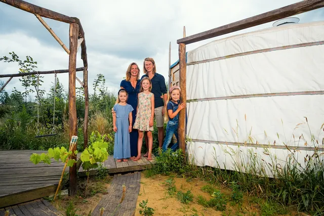 Chantal en Dirk-Jan van ‘Waar doen ze het van?’ met hun drie kinderen voor hun huis.