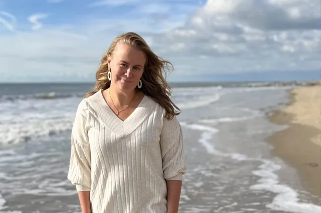 Lieneke van 38 loopt over het strand. Ze heeft lange donkerblonde haren en het waait.