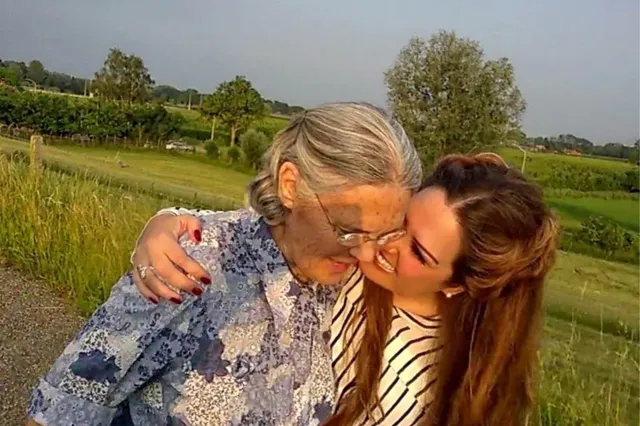 Stephanie en moeder, knuffelend in het zonnetje.