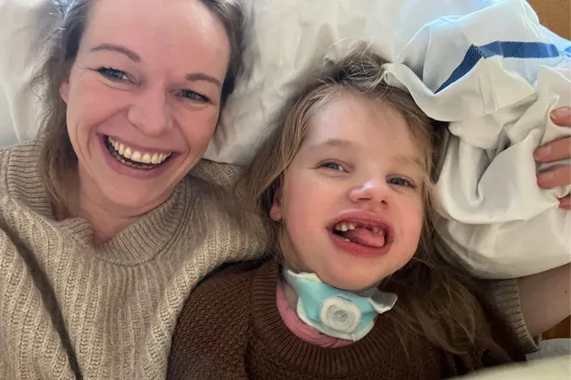 Op de selfie ligt Nynke met haar dochter Siri lachend op bed. Ze dragen beide een bruine trui en hebben blond haar.