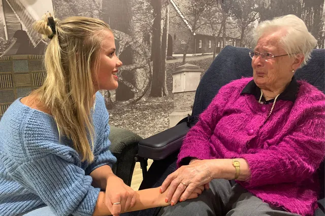 Yvon zingt en houdt de hand vast van een vrouw met dementie.