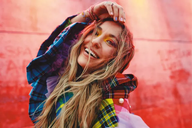 De cover van het album van Lauren Daigle. Ze staat er dansend op met veel kleuren.