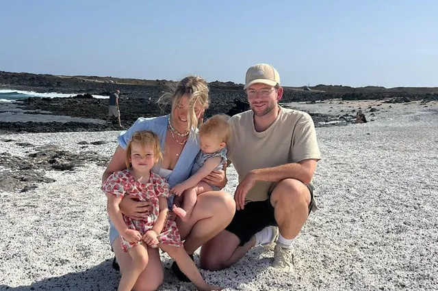 Bas Derks met zijn vrouw en twee dochters op het strand.