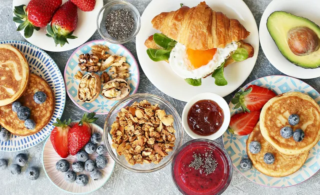 Een paastafel vol lekkers: pannenkoekjes, croissantjes, yoghurt en fruit.