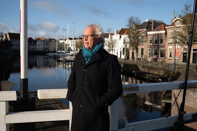 Egbert Rietveld, staat op een brug met zijn winterjas aan in de zon. Hij schreef het boek 'Dichter van leegte', toen zijn vrouw gediagnostiseerd werd met alzheimer.