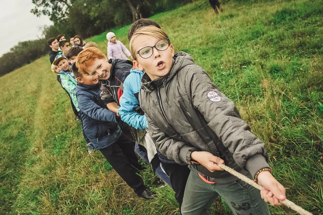 Kinderen touwtrekken op een zomerkamp.