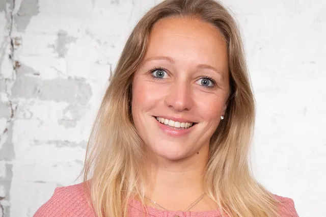 Brenda met blond haar lacht in de camera.