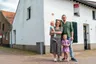 Bette en Robin Koenjer met hun twee kinderen Liv en Ben voor hun huis in Limburg